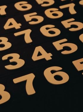 Close-up view of wooden numbers arranged on a black surface, ideal for educational themes.