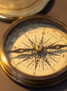 Close-up of a vintage brass compass, emphasizing its nautical design and retro charm.